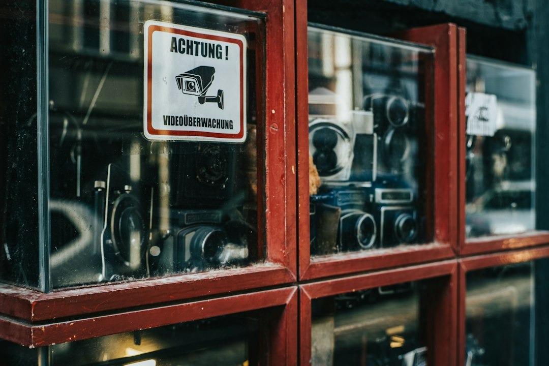 Security warning sign on a display case of vintage cameras.